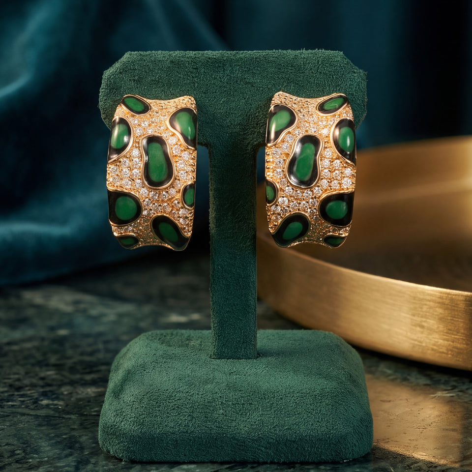 Green pavé leopard hoops on a green velvet stand on marble