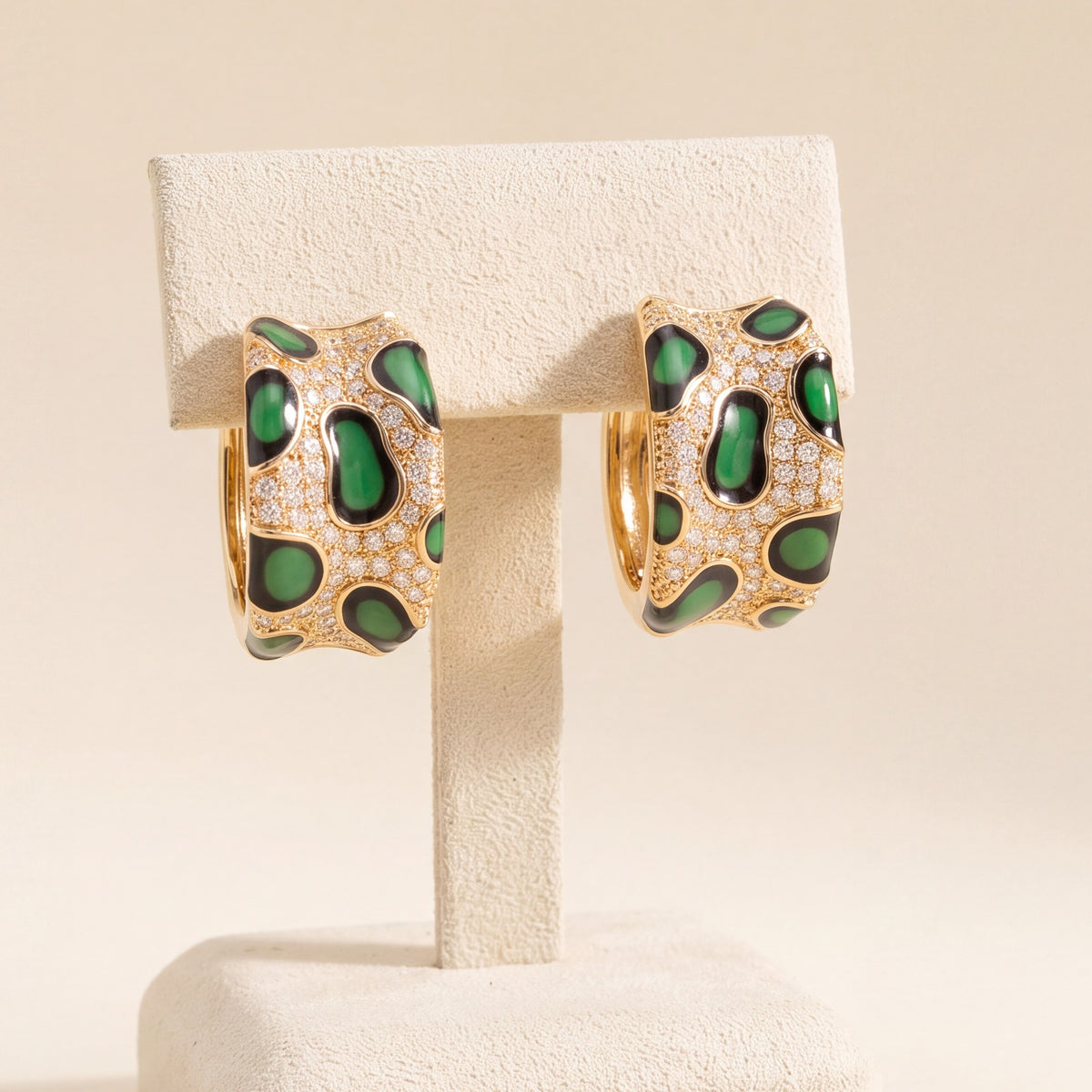 Green pavé leopard hoops on an ivory stand