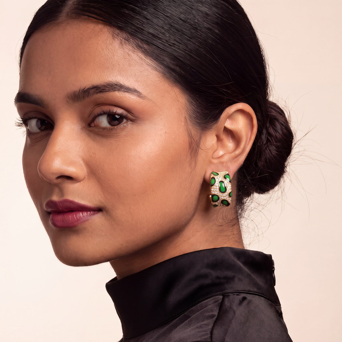 Green pavé leopard hoops worn with a black high-neck top